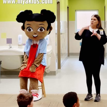 Mya mascot with teacher and students in classroom environment