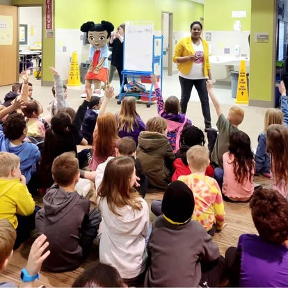 Mya mascot with diverse group of children at school event